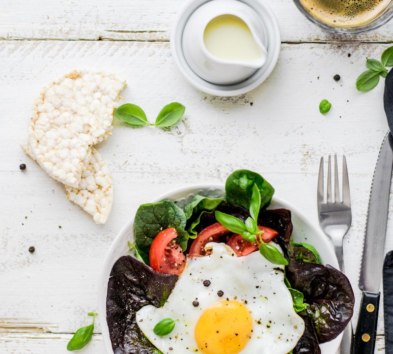 flat-lay photography of lettuce with fried egg and flatbread