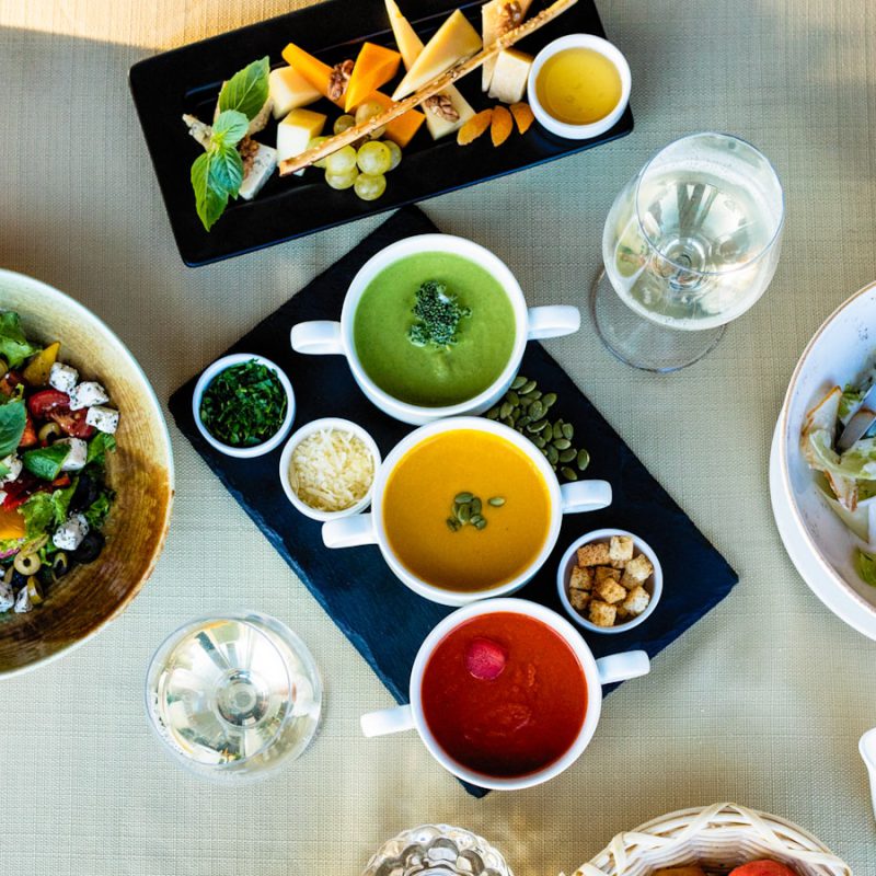 sliced bread with sliced tomato and green leaf vegetable on white ceramic plate